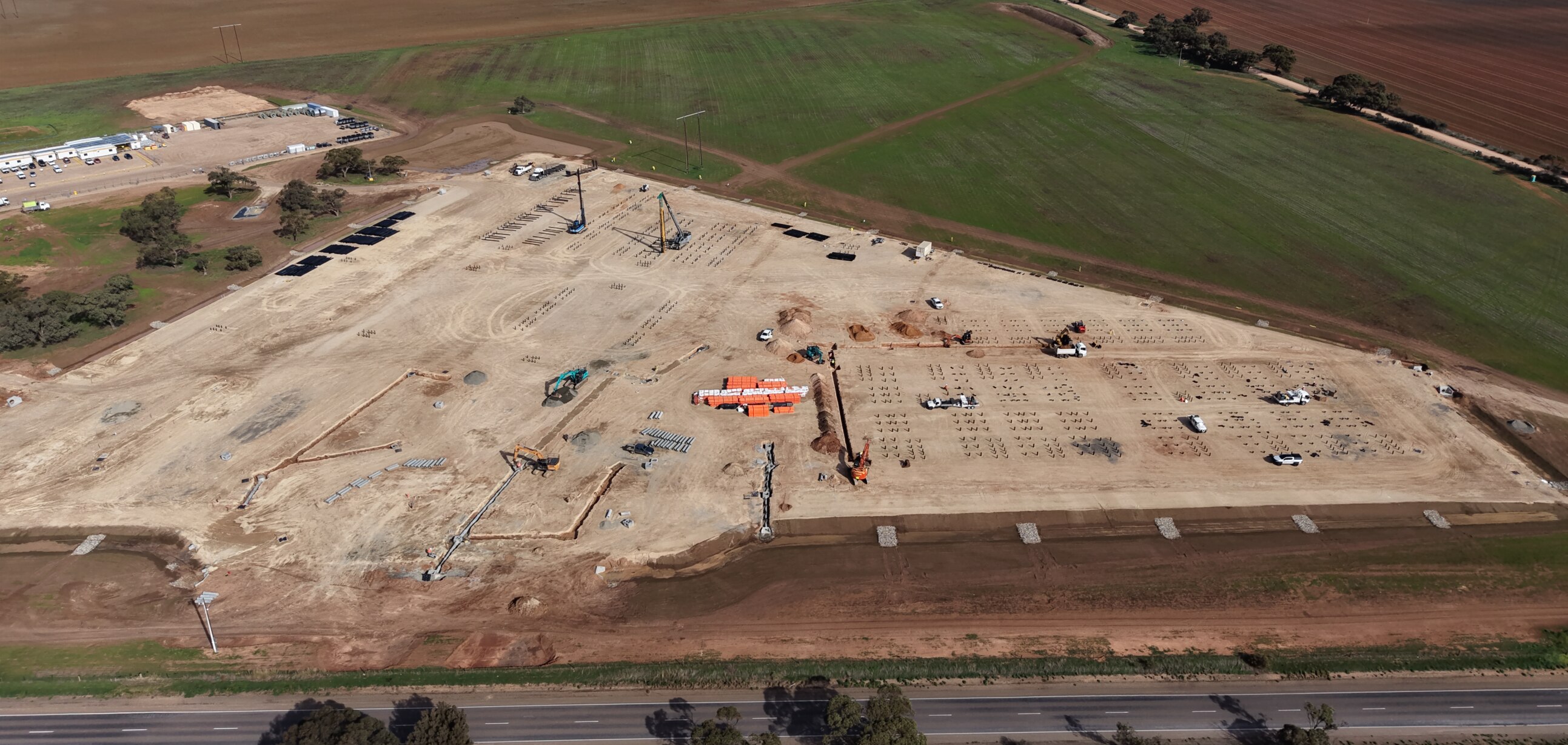 Four Alinta Energy workers in hi-vis and white hard hats stand side by side with their arms crossed smiling.