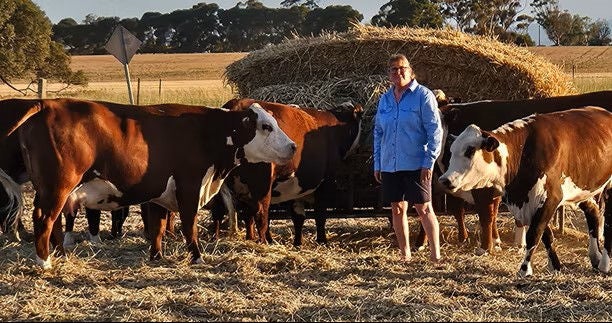 Jo on her farm with cows.